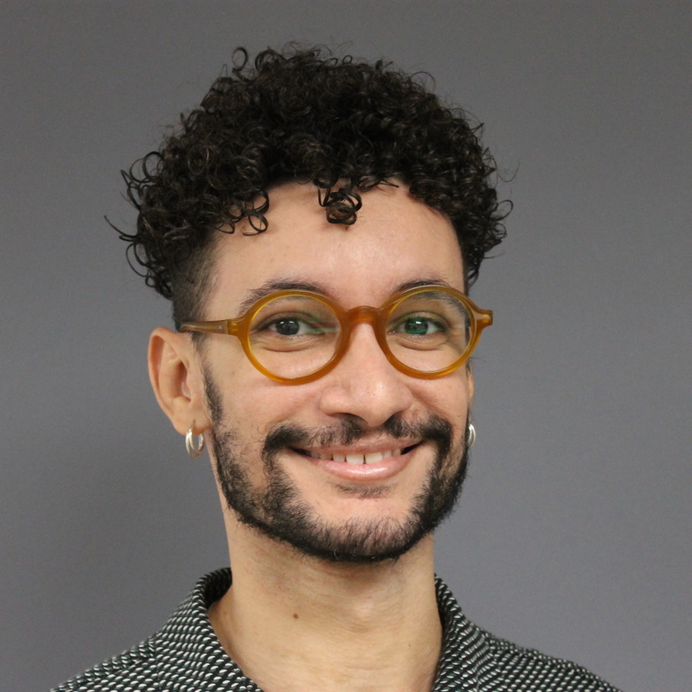 person with curly hair and glasses