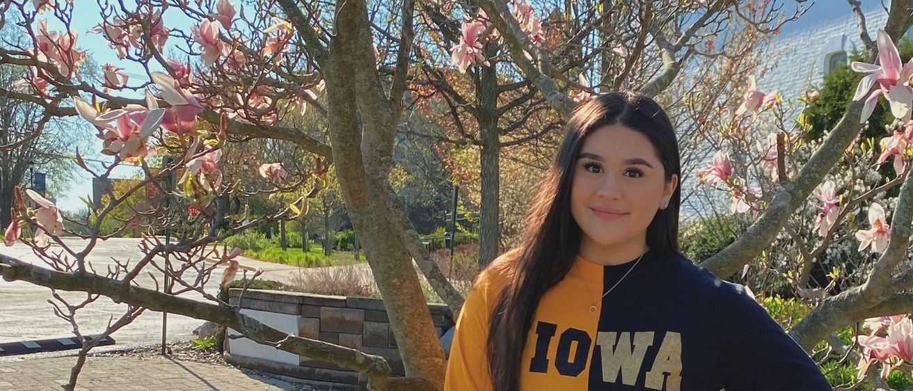 Carolina Duenas standing in Iowa colors in front of a tree