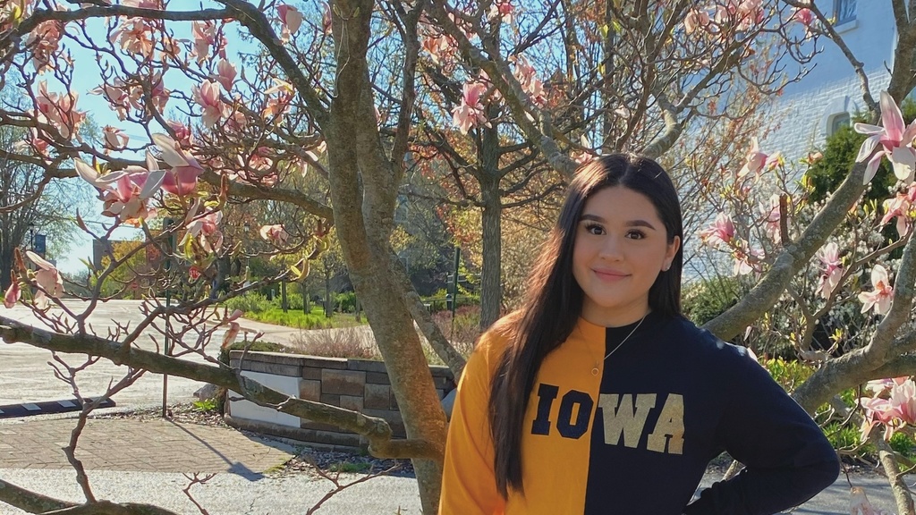 Carolina Duenas standing in Iowa colors in front of a tree