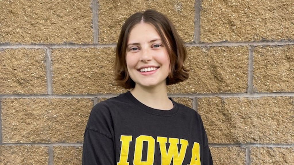 Christina Fjeld standing against a brick wall in an Iowa t-shirt