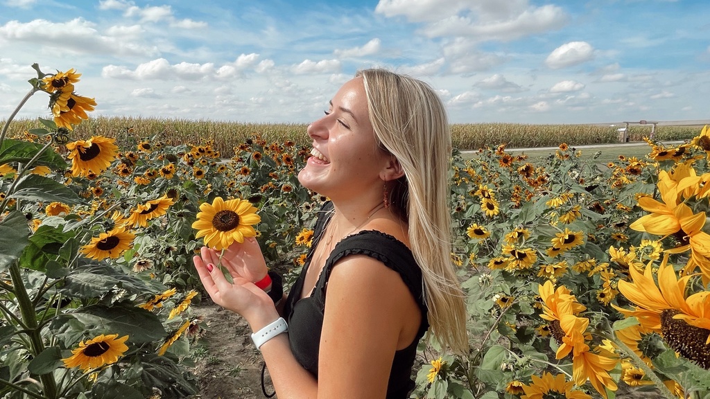 Delaney Orewiler standing in a sunflower field