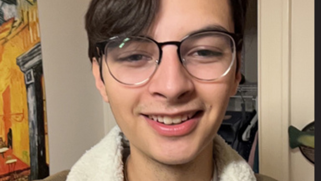 young man with short dark brown hair and glasses